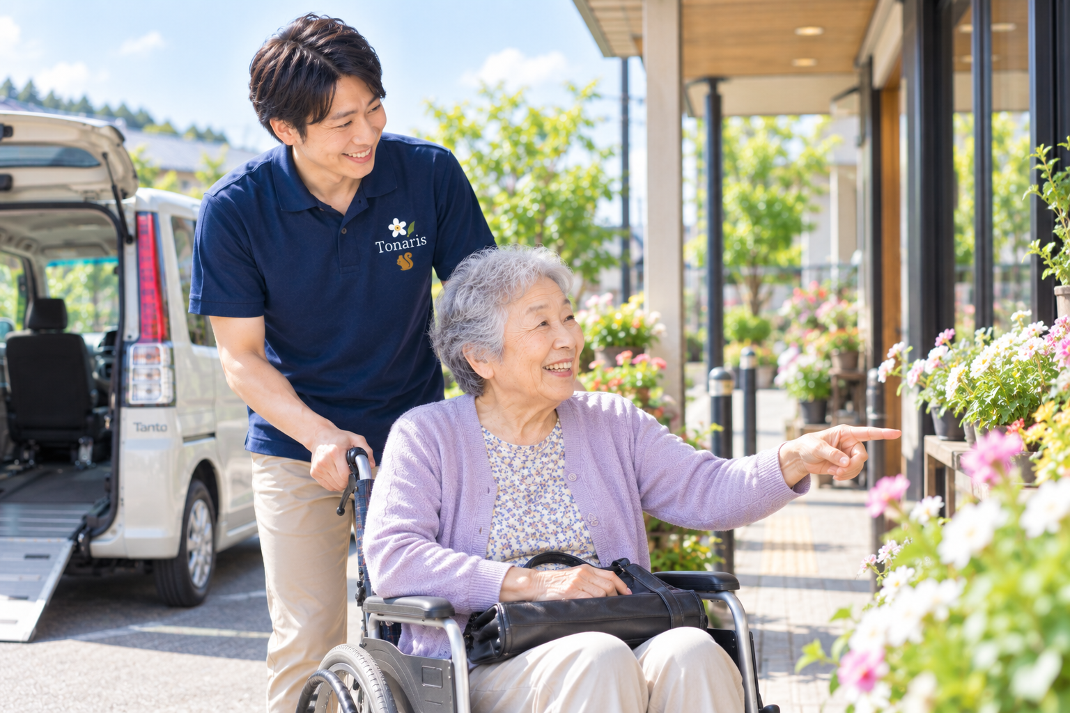 車いすの利用者を笑顔でサポートしながら外出するスタッフ
