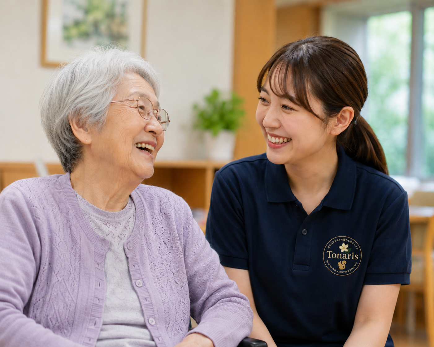 笑顔で会話をするご高齢の女性とTonarisのスタッフ